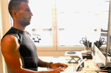 Personalworkout Inhaber Marc Sonderegger tippt an einem Stehpult auf einer Computertastatur und schaut in Richtung Monitor.