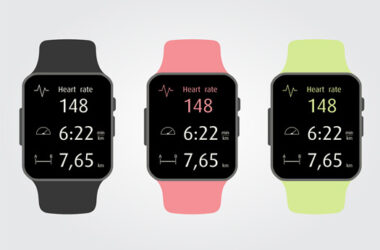 Drei Fitness-Smartwatches mit verschiedenfarbigen Armbändern zeigen auf ihren Displays die Herzfrequenz und andere Trainingsdaten.