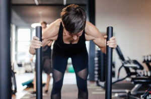 Eine Klientin von Personalworkout führt mit Energie und Fokus einen Sled Push aus, eine herausfordernde Übung, die Beine, Oberkörper und das Herz-Kreislaufsystem effektiv stärkt und für ein intensives Training sorgt.
