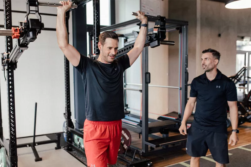Marc Sonderegger, Personal Trainer und Inhaber von Personalworkout, betreut einen Kunden beim Training mit den Jammer Arms im Fitnessstudio von Personalworkout. Die Jammer Arms sind ideal für Athletik- und Schnellkrafttraining.