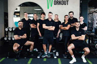 Das Trainer- und Therapeuten-Team von Personalworkout mit Inhaber Marc Sonderegger in der Mitte, gekleidet in schwarze Sportkleidung, posiert entspannt vor der hellen Fitnessstudio-Kulisse.