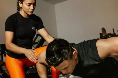 Eine junge Trainerin motiviert einen muskulösen Mann zum Krafttraining